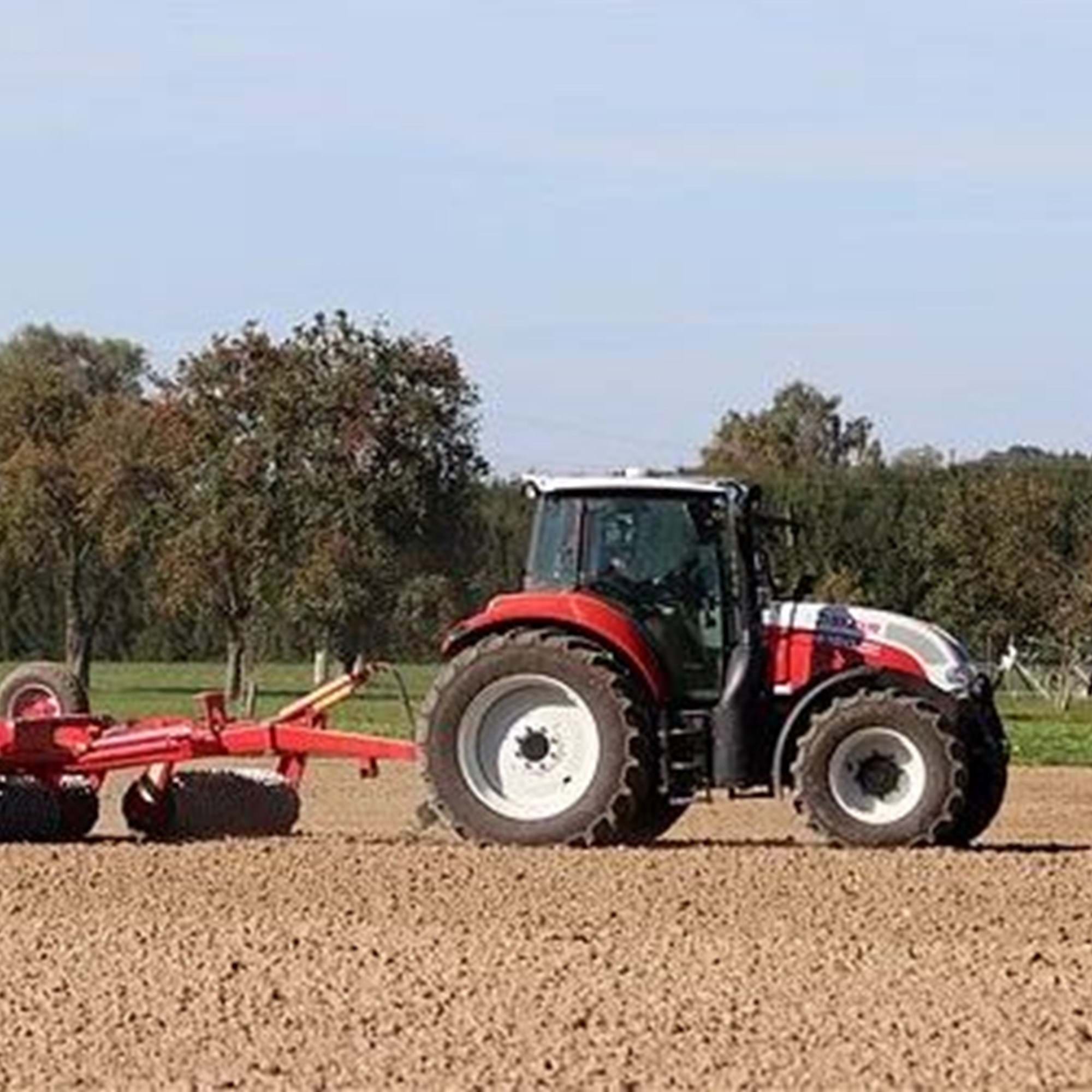 Weiß-roter Traktor mit Anhänger