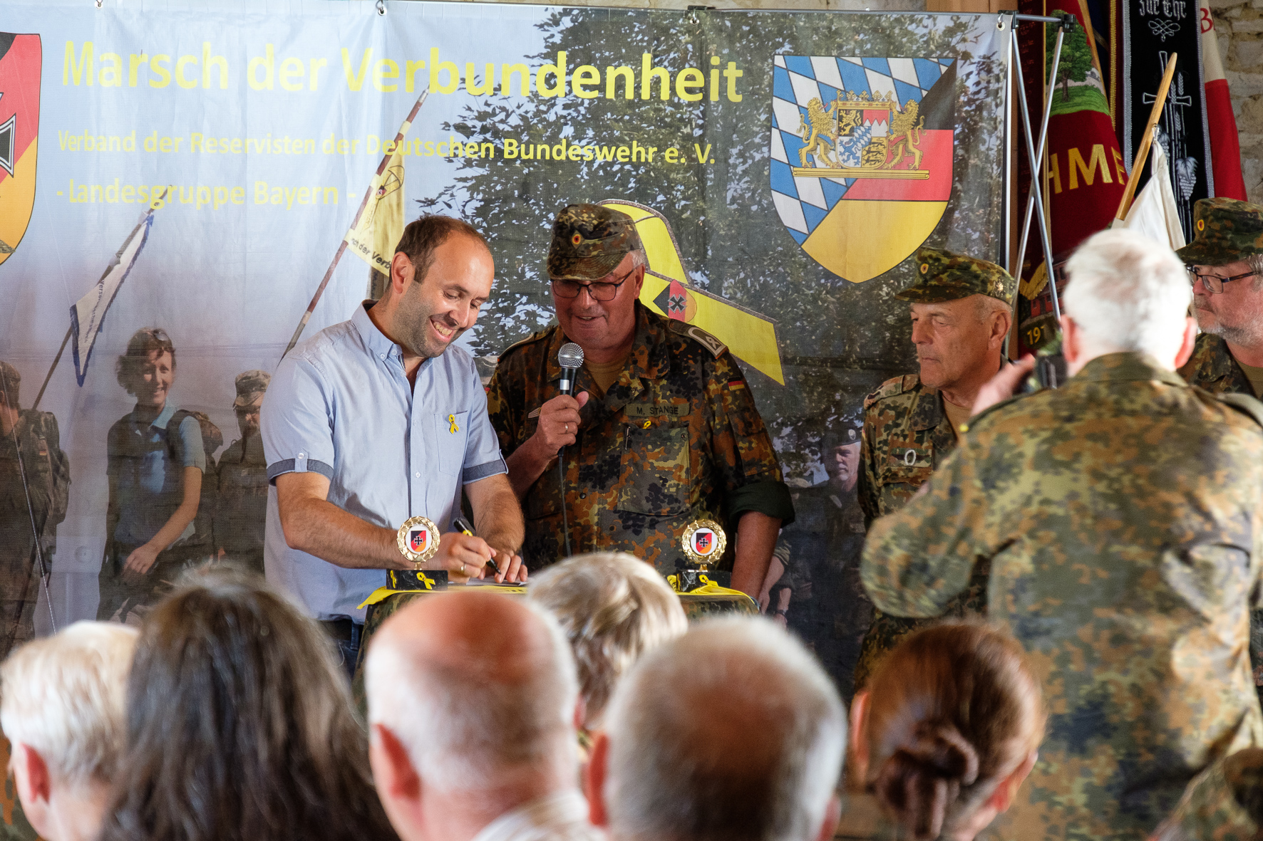 Bürgermeister Jürgen Nadler unterschreibt auf dem gelben Band